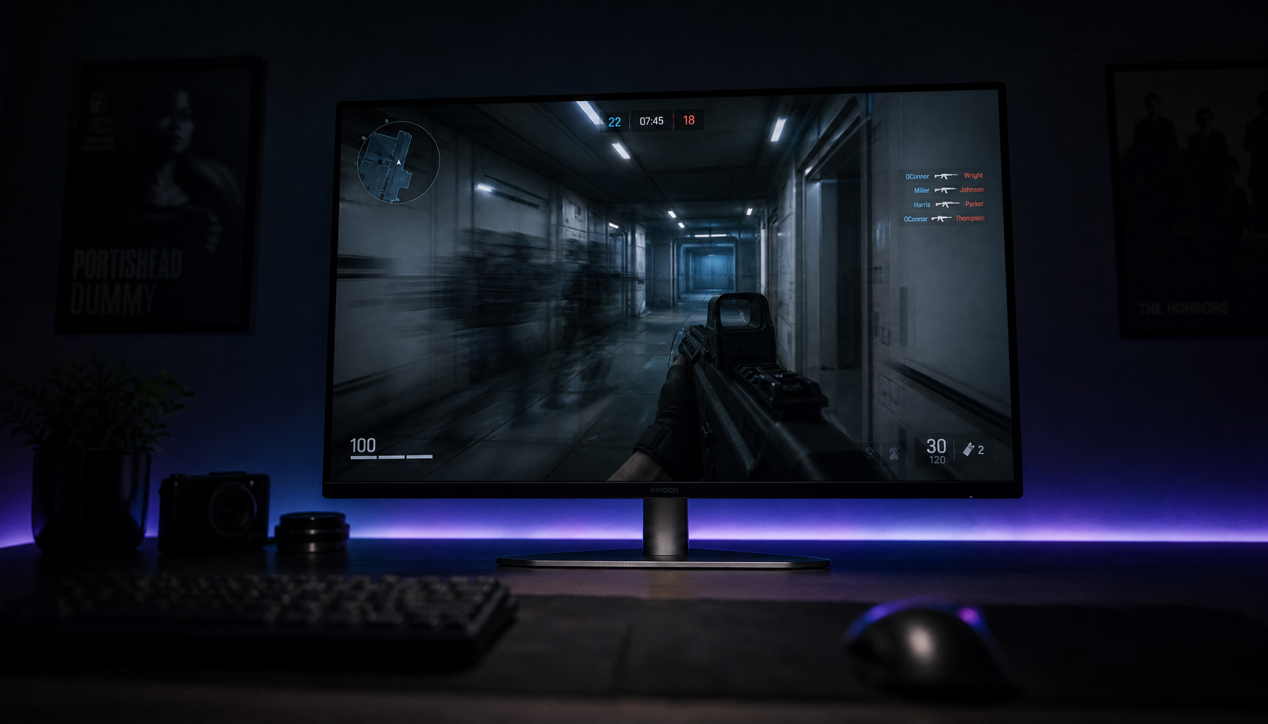 Gaming monitor on a dark desk displaying a first-person shooter scene with visible motion blur and ghost trail, illustrating display artifacts in fast-paced games
